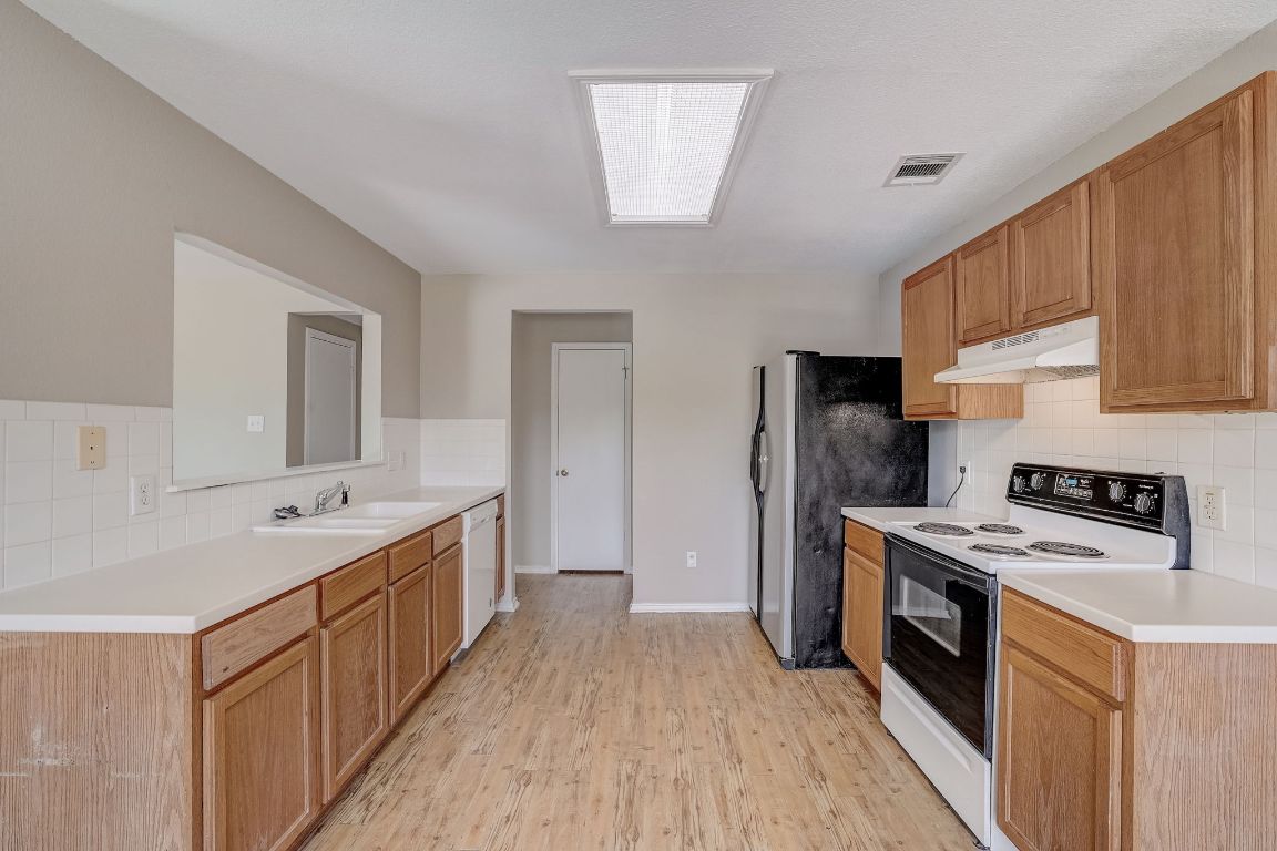 314 Bello Drive Leander, TX 78641 - Photo 13 of 35 a kitchen with a sink stove and refrigerator