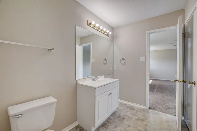 a bathroom with a toilet sink and mirror