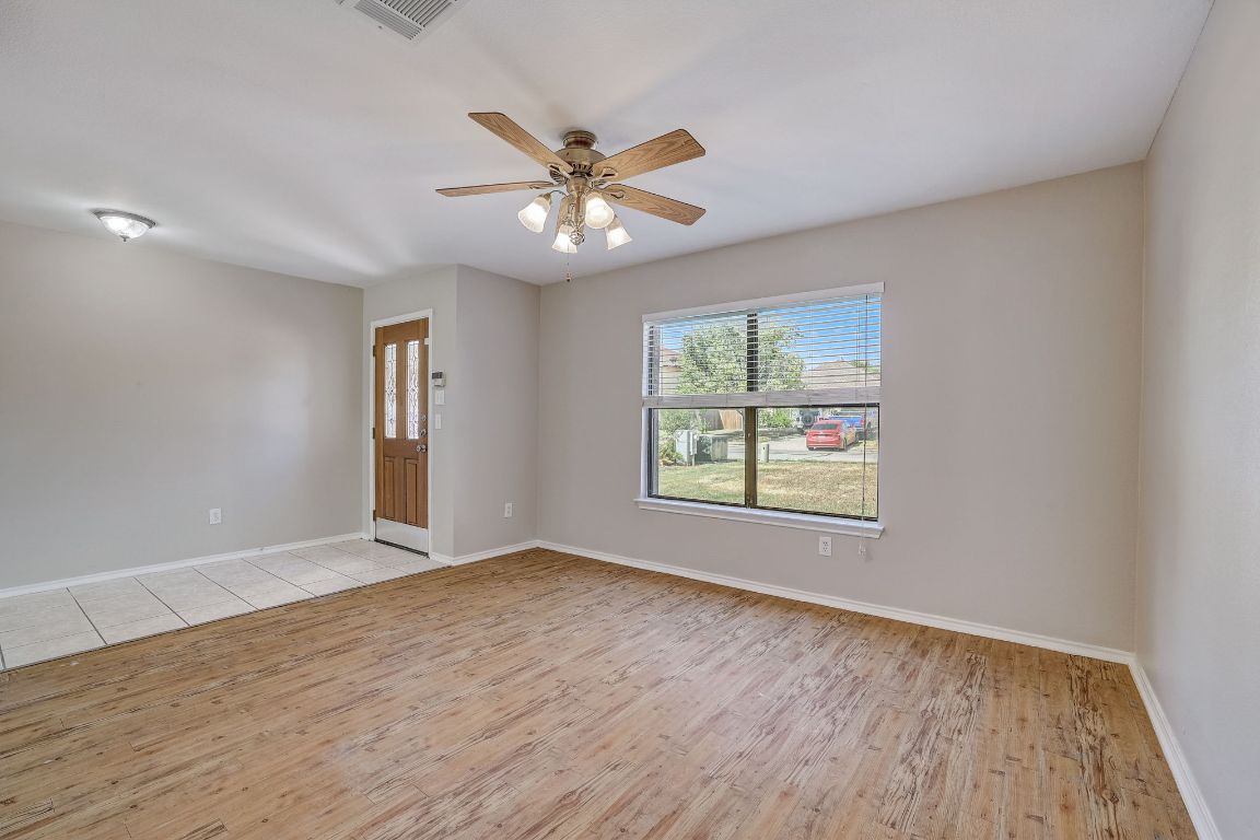 314 Bello Drive Leander, TX 78641 - Photo 5 of 35 an empty room with wooden floor fan and windows