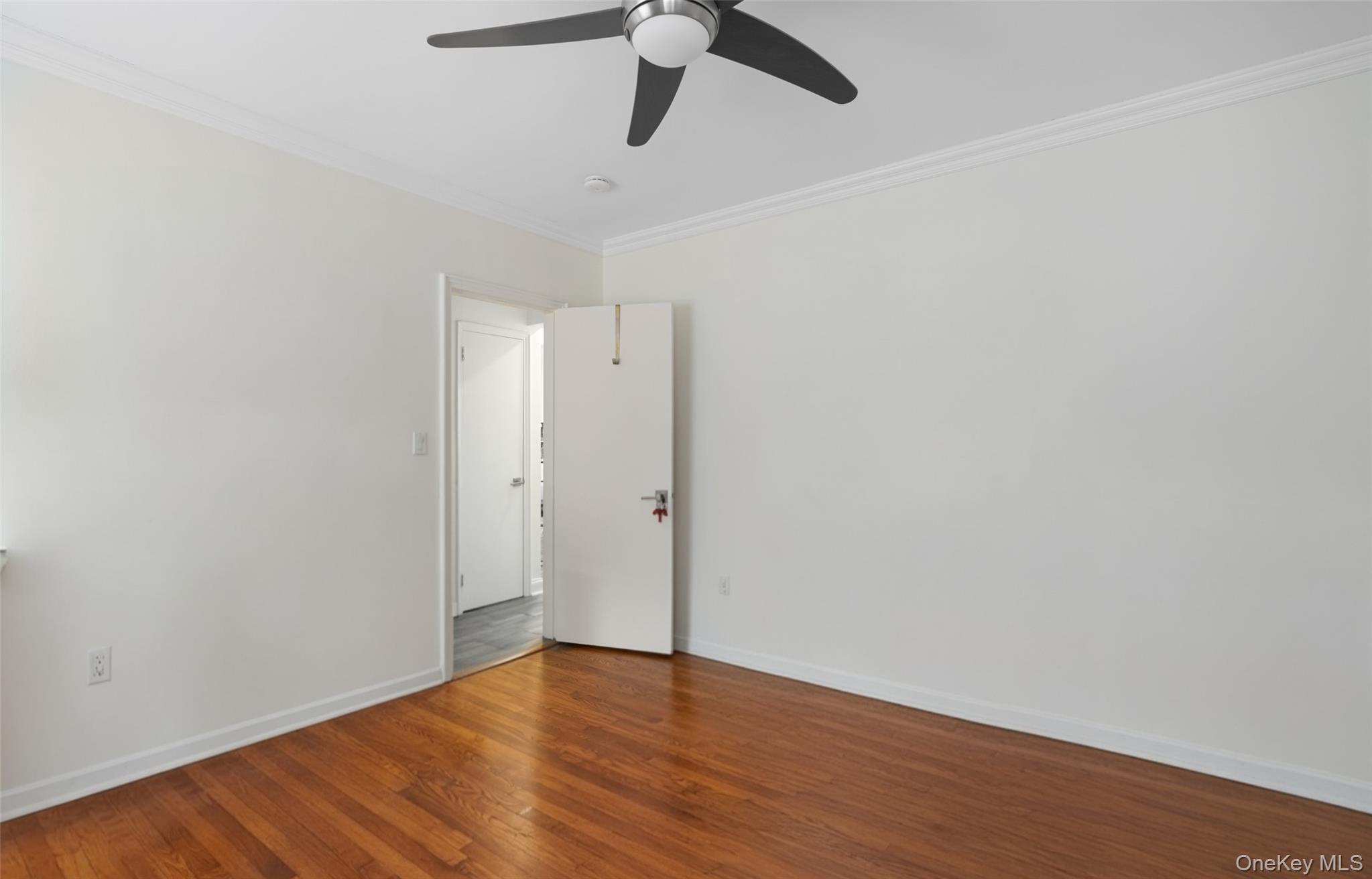19-50 80th Street, Unit 1 Queens, NY 11370 - Photo 11 of 20 a view of an empty room with wooden floor and window
