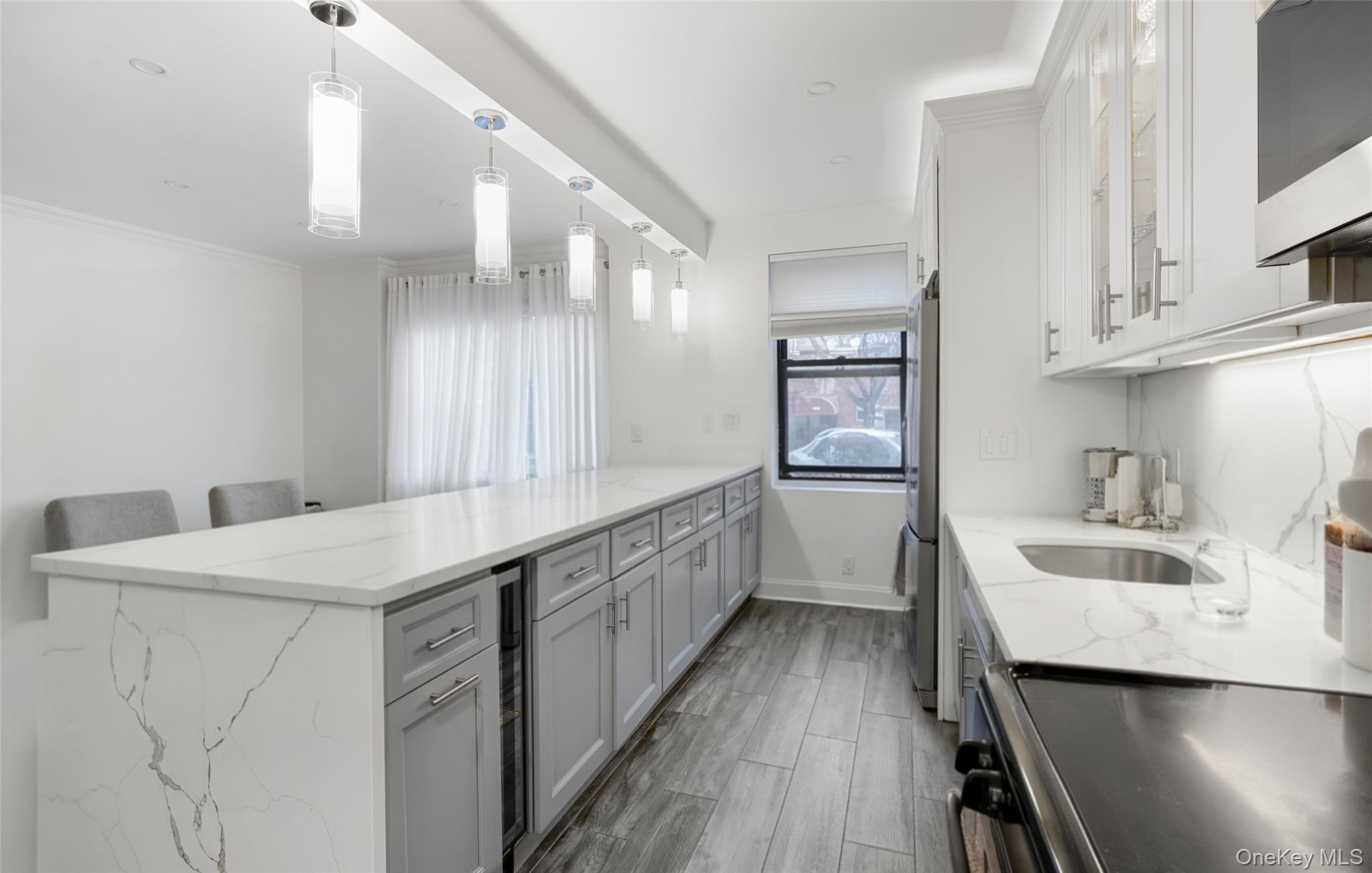 19-50 80th Street, Unit 1 Queens, NY 11370 - Photo 2 of 20 a kitchen with sink cabinets and wooden floor