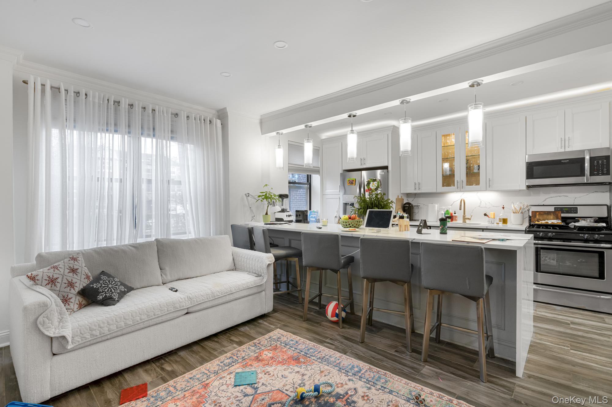 19-50 80th Street, Unit 1 Queens, NY 11370 - Photo 5 of 20 a living room with stainless steel appliances kitchen island furniture and a large window