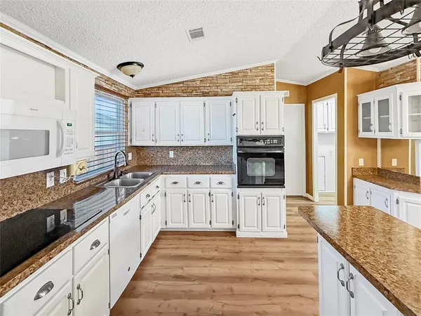 a view of a kitchen with wooden floor and a window