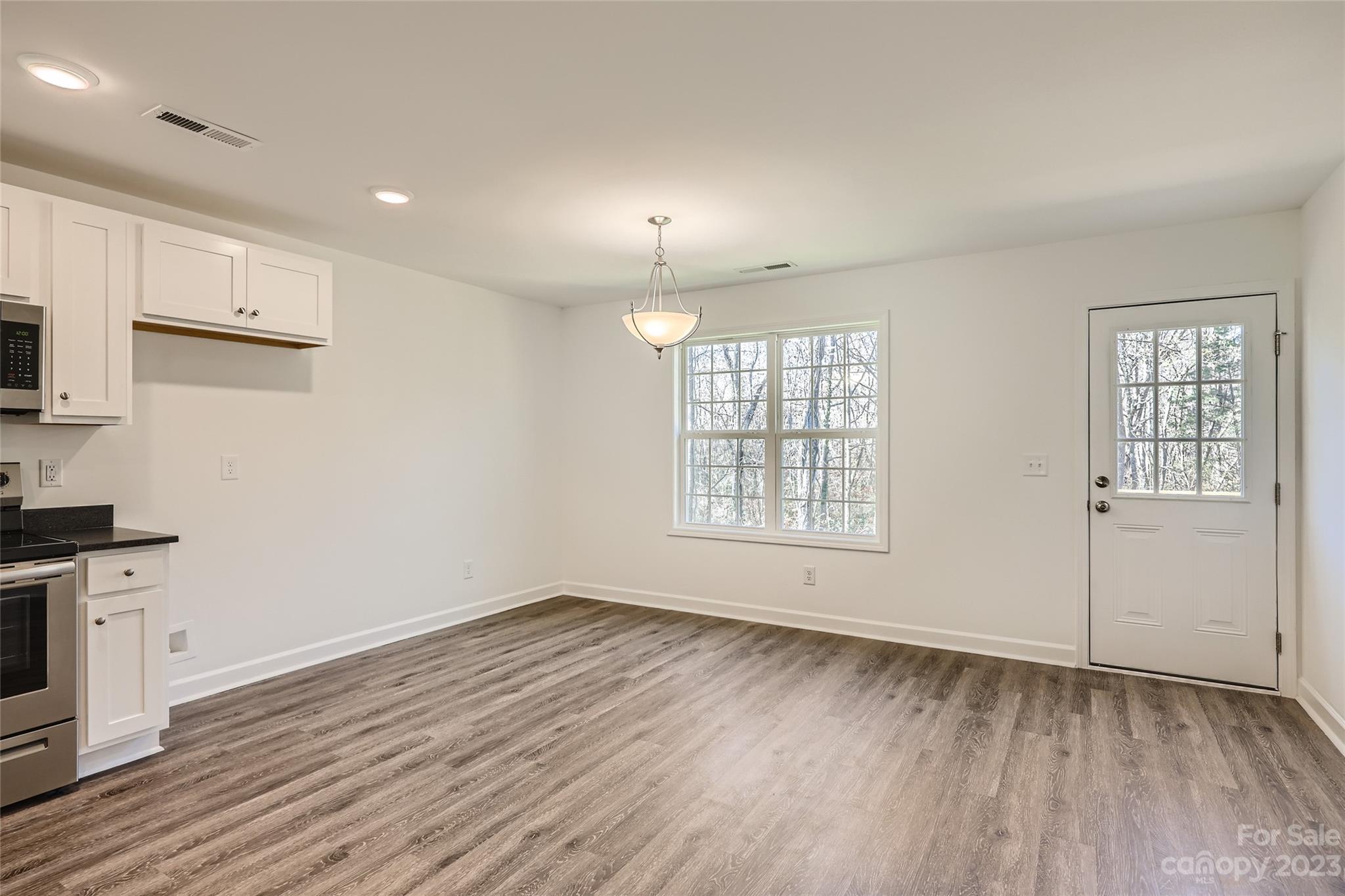 1 Hampton Church Road Charlotte, NC 28262 - Photo 4 of 11 an empty room with wooden floor and windows