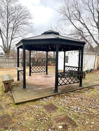 a view of a backyard of a house with a wooden floor and outdoor seating