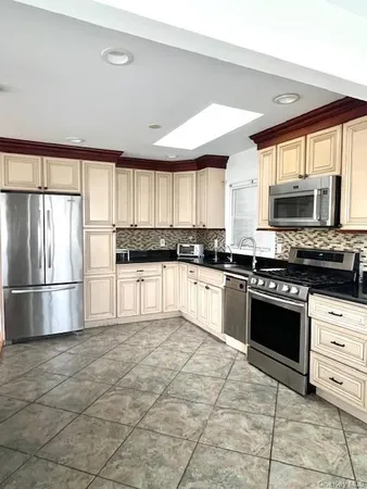 a kitchen with stainless steel appliances granite countertop a stove a sink and a refrigerator