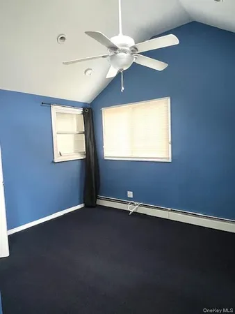 an empty room with a window and a ceiling fan