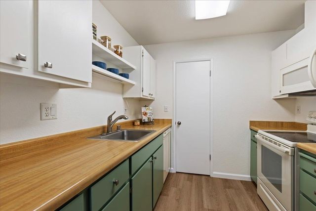 a kitchen with stainless steel appliances granite countertop a sink and a stove