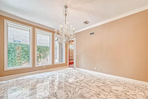 a view of a livingroom with a chandelier and kitchen view