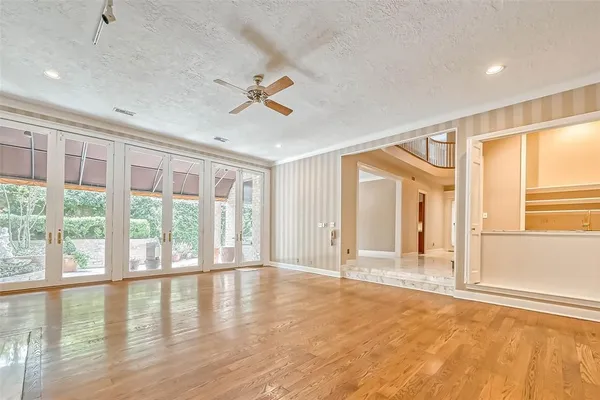 a view of an empty room with a window and wooden floor