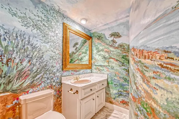 a bathroom with a granite countertop sink and a toilet