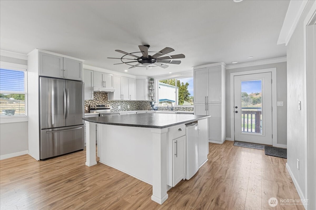 770 Lancaster Road Selah, WA 98942 - Photo 6 of 37 a kitchen with granite countertop a refrigerator a sink dishwasher and a stove with wooden floor