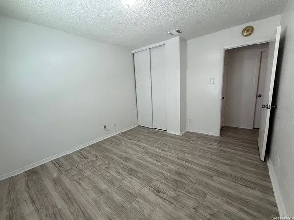 a view of empty room with wooden floor