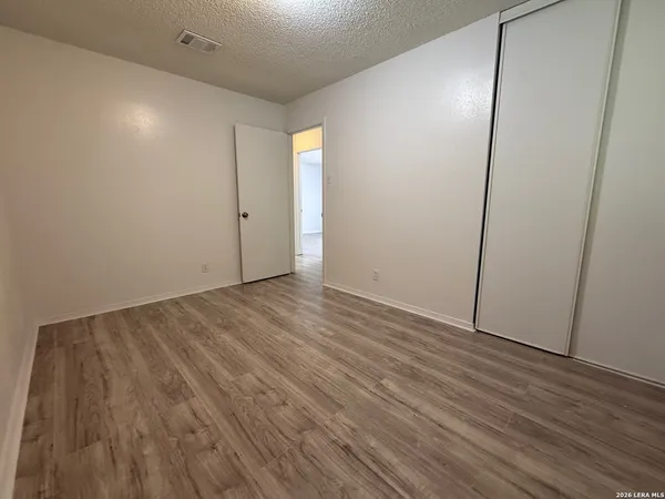 a view of an empty room with wooden floor