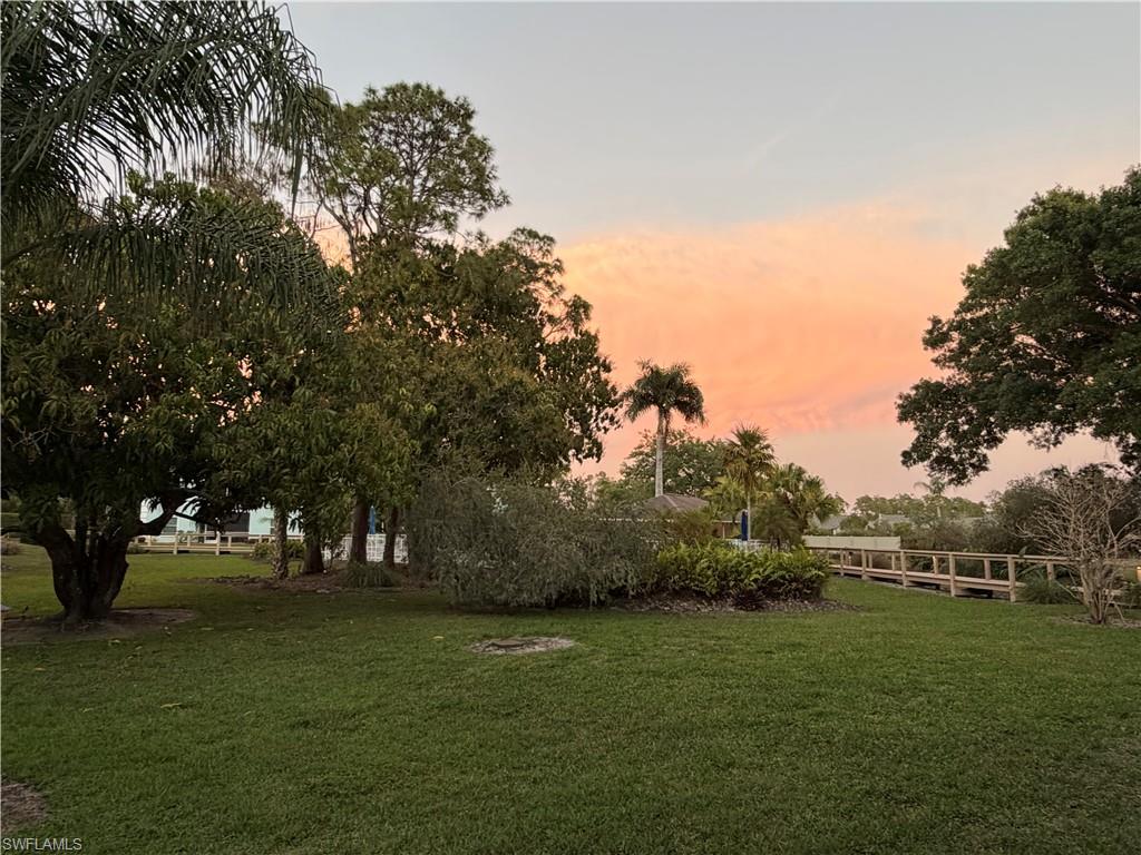 5737 Whitaker Road, Unit C101 Naples, FL 34112 - Photo 27 of 28 a view of outdoor space with green field and trees
