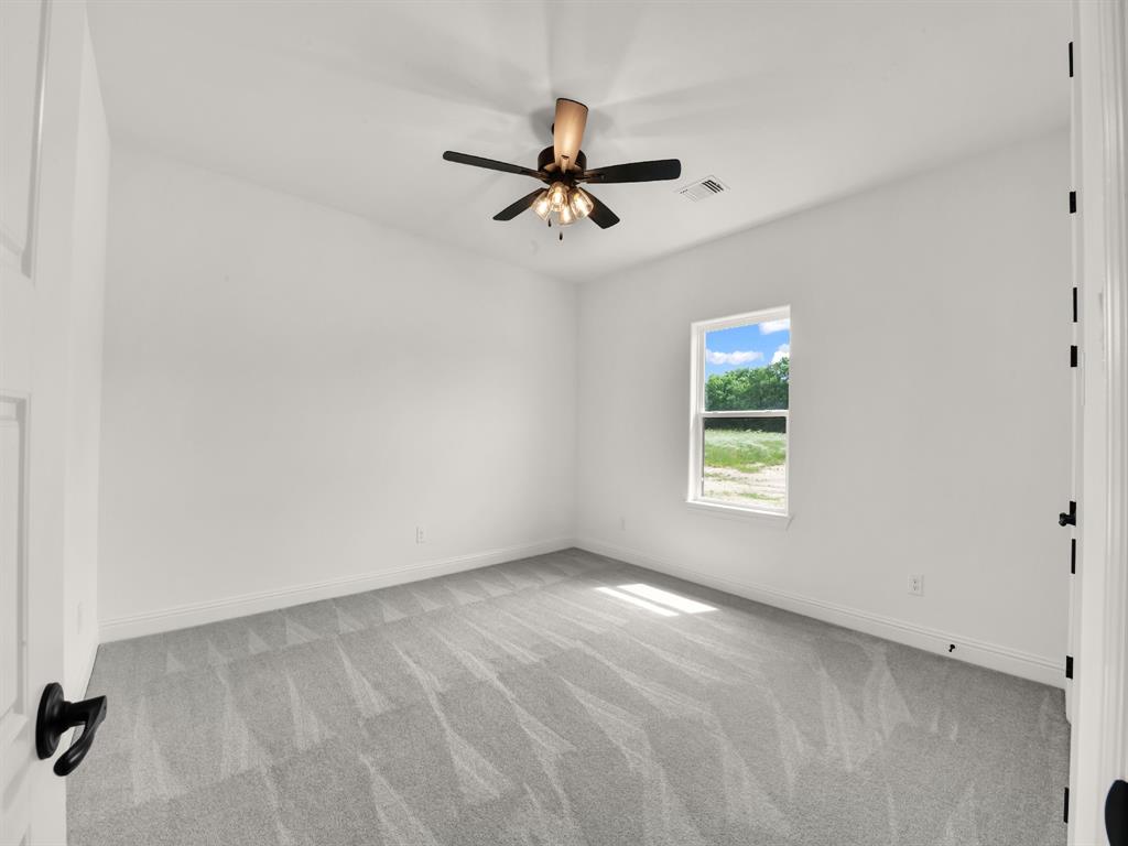 143 Desperado Way Weatherford, TX 76088 - Photo 35 of 36 Carpeted empty room with ceiling fan and baseboards