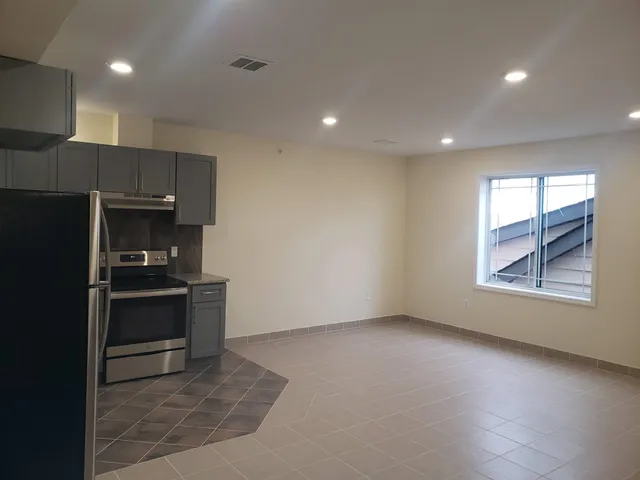 a kitchen with granite countertop a refrigerator and a sink
