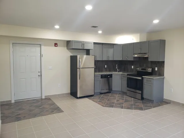 a kitchen with stainless steel appliances granite countertop a refrigerator and a stove top oven