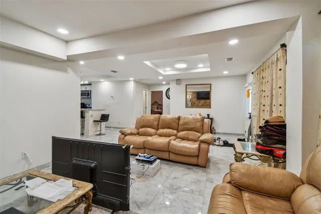 a kitchen with stainless steel appliances granite countertop a stove top oven a sink dishwasher a dining table and chairs with wooden floor