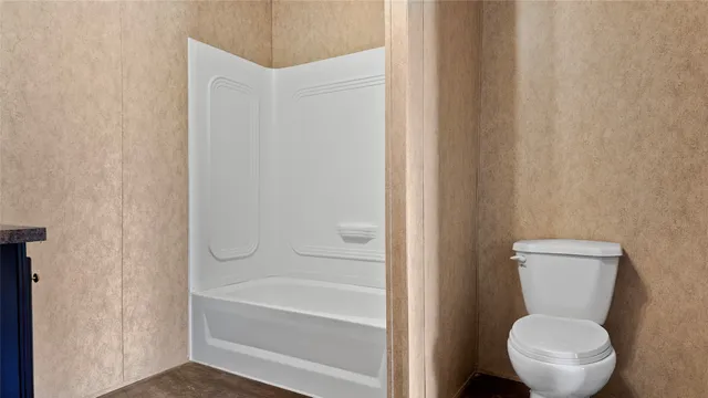 a white toilet sitting next to a bath tub