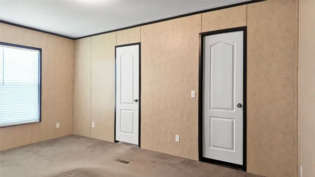 an empty room with windows and closet