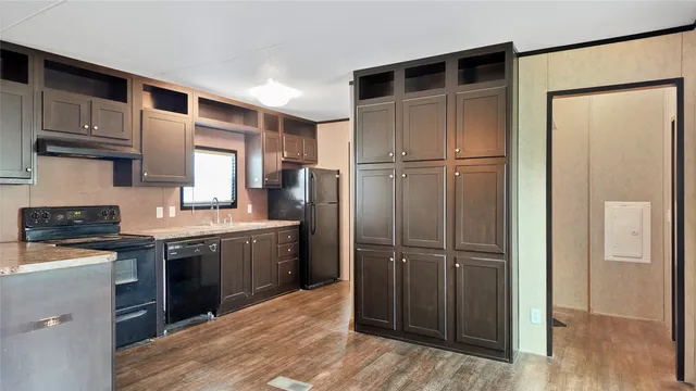 a kitchen with kitchen island granite countertop wooden cabinets and a refrigerator