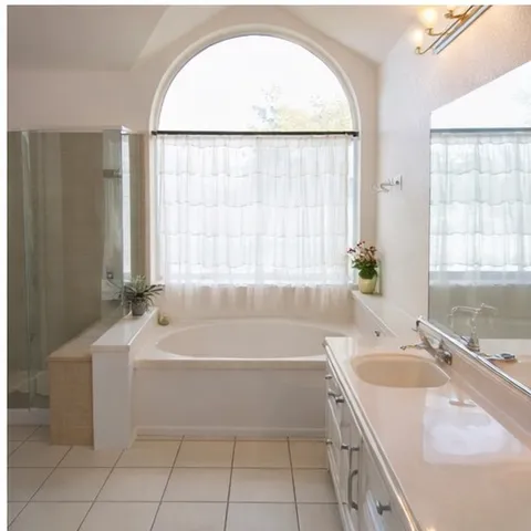 a bathroom with a tub sink and mirror