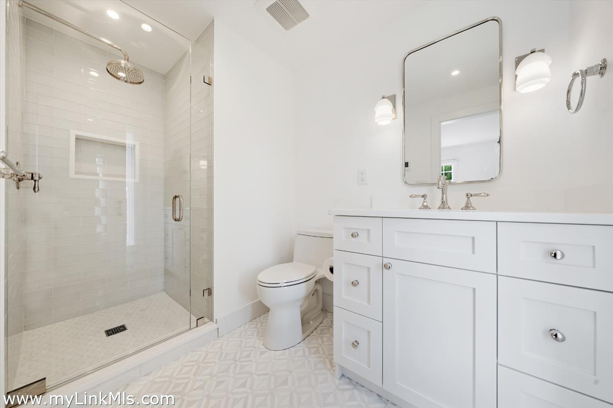 10 North Water Street Nantucket, MA 02554 - Photo 26 of 78 a bathroom with a toilet a sink a glass door a shower and vanity