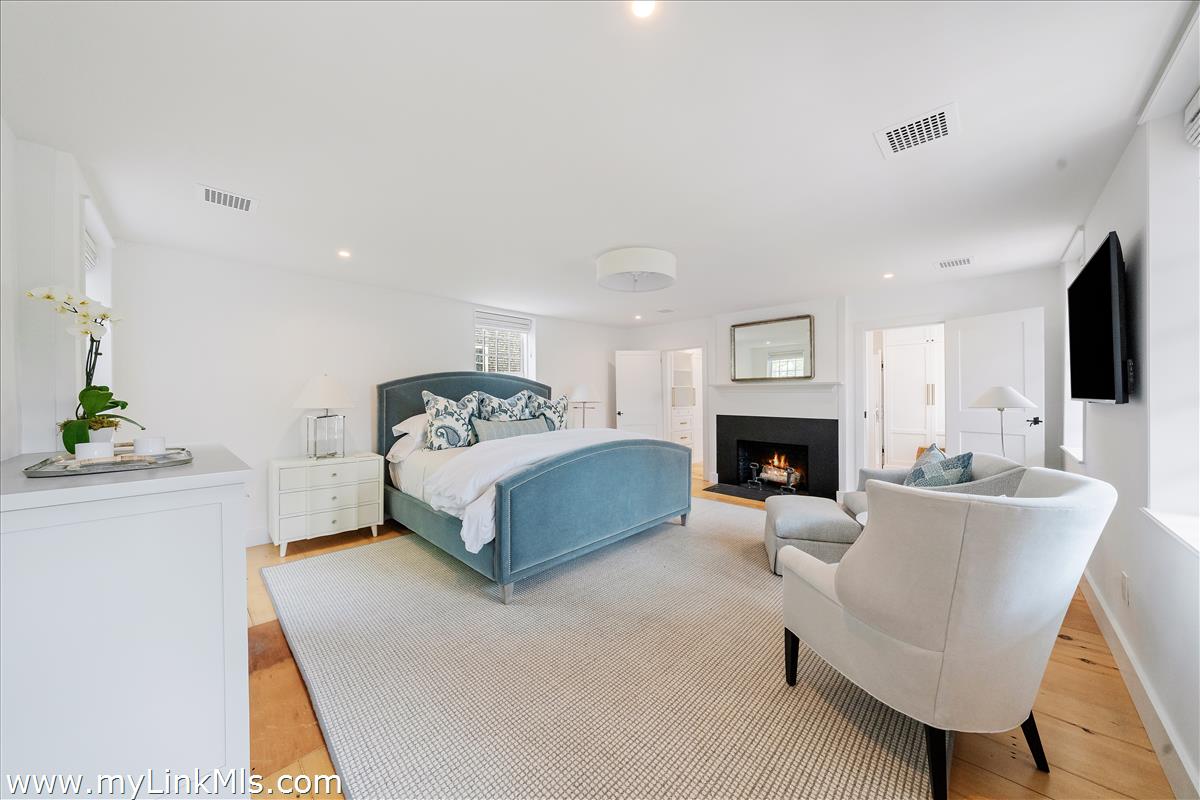 10 North Water Street Nantucket, MA 02554 - Photo 36 of 78 a spacious bedroom with a bed a couch and a flat tv screen on the dresser