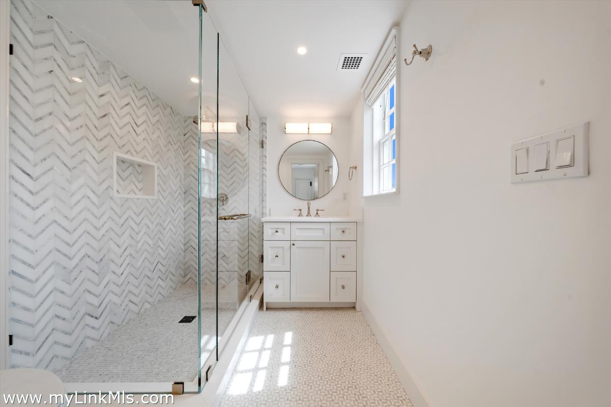 10 North Water Street Nantucket, MA 02554 - Photo 51 of 78 a bathroom with a sink a light fixture and a glass door shower