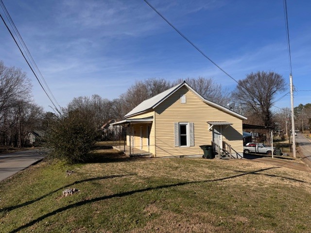 139 Columbia Avenue Centerville, TN 37033 - Photo 4 of 44 a view of a white house with a big yard and large trees
