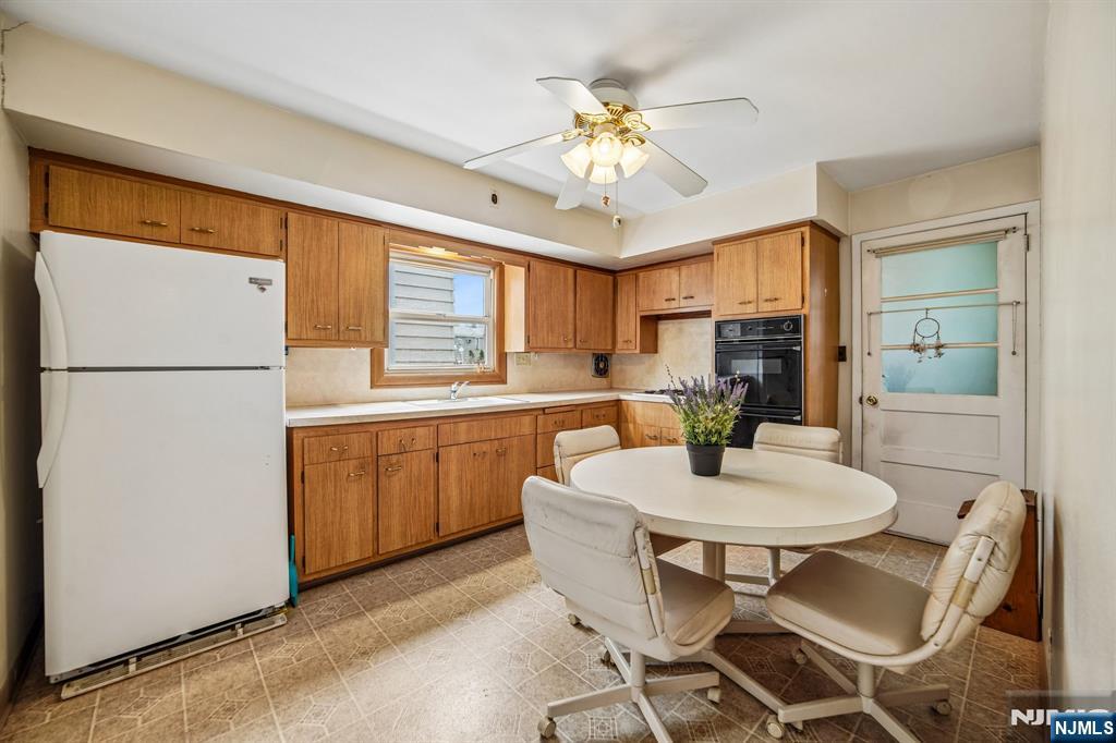 31 Division Street Bloomfield, NJ 07003 - Photo 11 of 30 a kitchen with a refrigerator a stove a sink dishwasher with a dining table and chairs