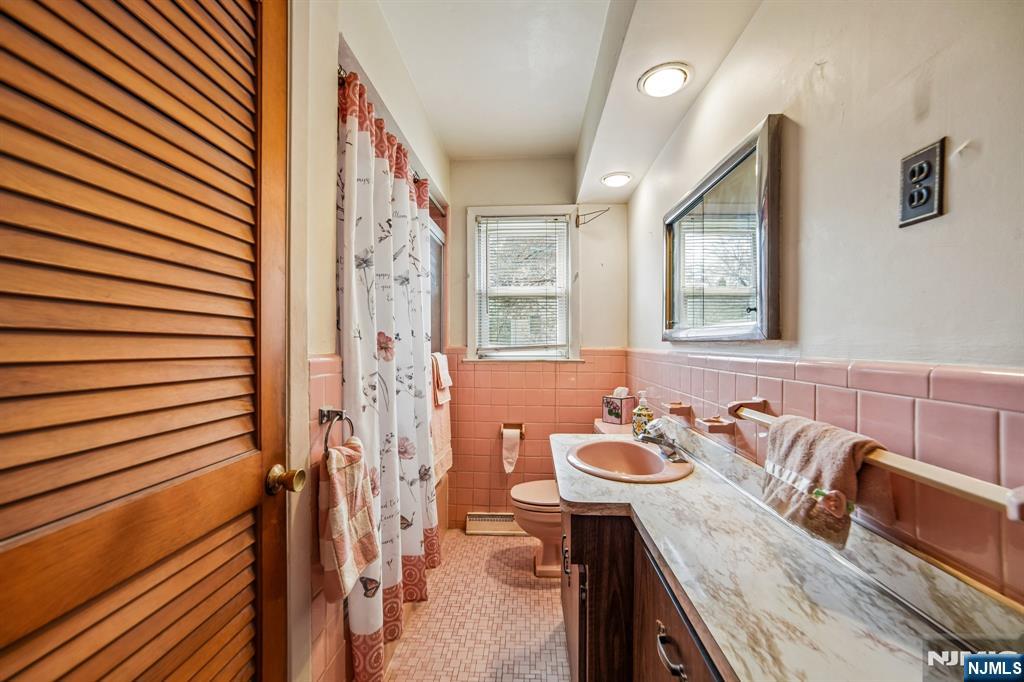 31 Division Street Bloomfield, NJ 07003 - Photo 15 of 30 a bathroom with a granite countertop sink and a mirror