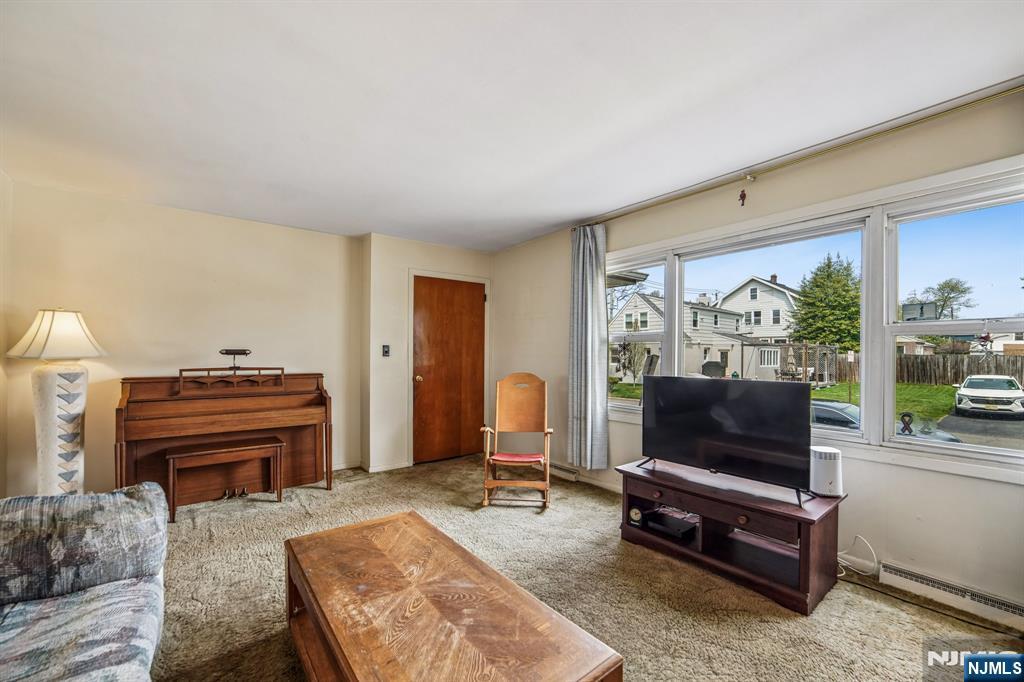 31 Division Street Bloomfield, NJ 07003 - Photo 6 of 30 a living room with furniture a flat screen tv and a floor to ceiling window