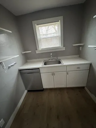 a room with a sink cabinets and a window
