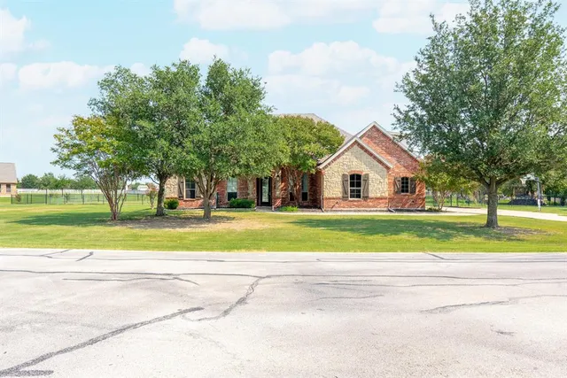 a view of house with outdoor space and trees in the background