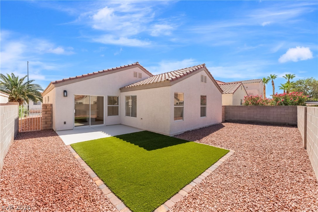 668 Rising Brook Drive Henderson, NV 89011 - Photo 20 of 22 A private yard with a compact green lawn and a spacious patio for outdoor leisure.