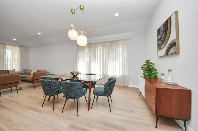 a kitchen with stainless steel appliances a sink table and chairs