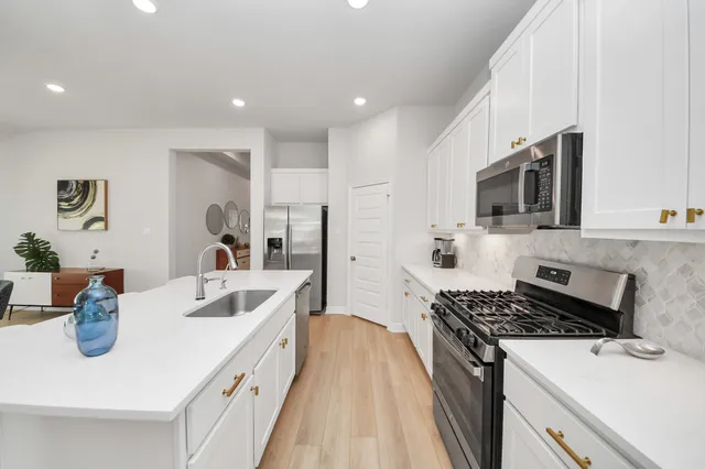 a large white kitchen with stainless steel appliances