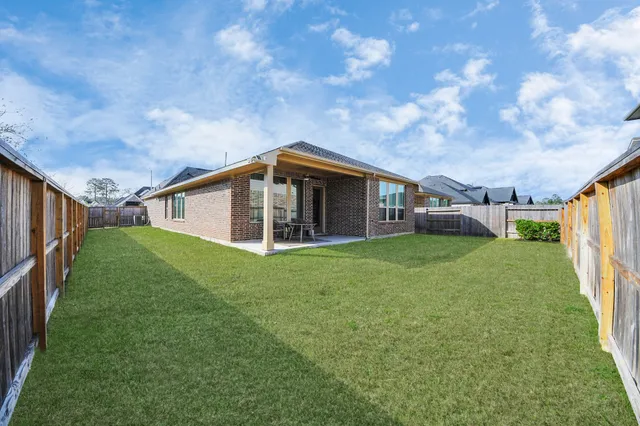 a view of backyard with table and chairs and potted plants