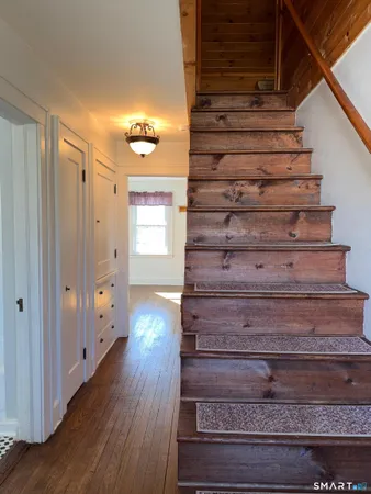 a view of entryway and hall with wooden floor