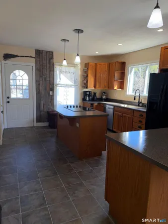 a large kitchen with granite countertop a stove a sink dishwasher and a refrigerator