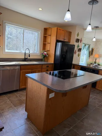 a kitchen with stainless steel appliances granite countertop a sink a microwave and wooden cabinets