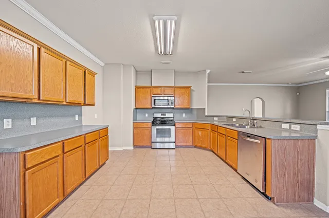 a large kitchen with stainless steel appliances granite countertop a stove and a sink