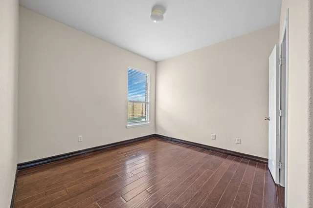 a view of a room with wooden floor and window