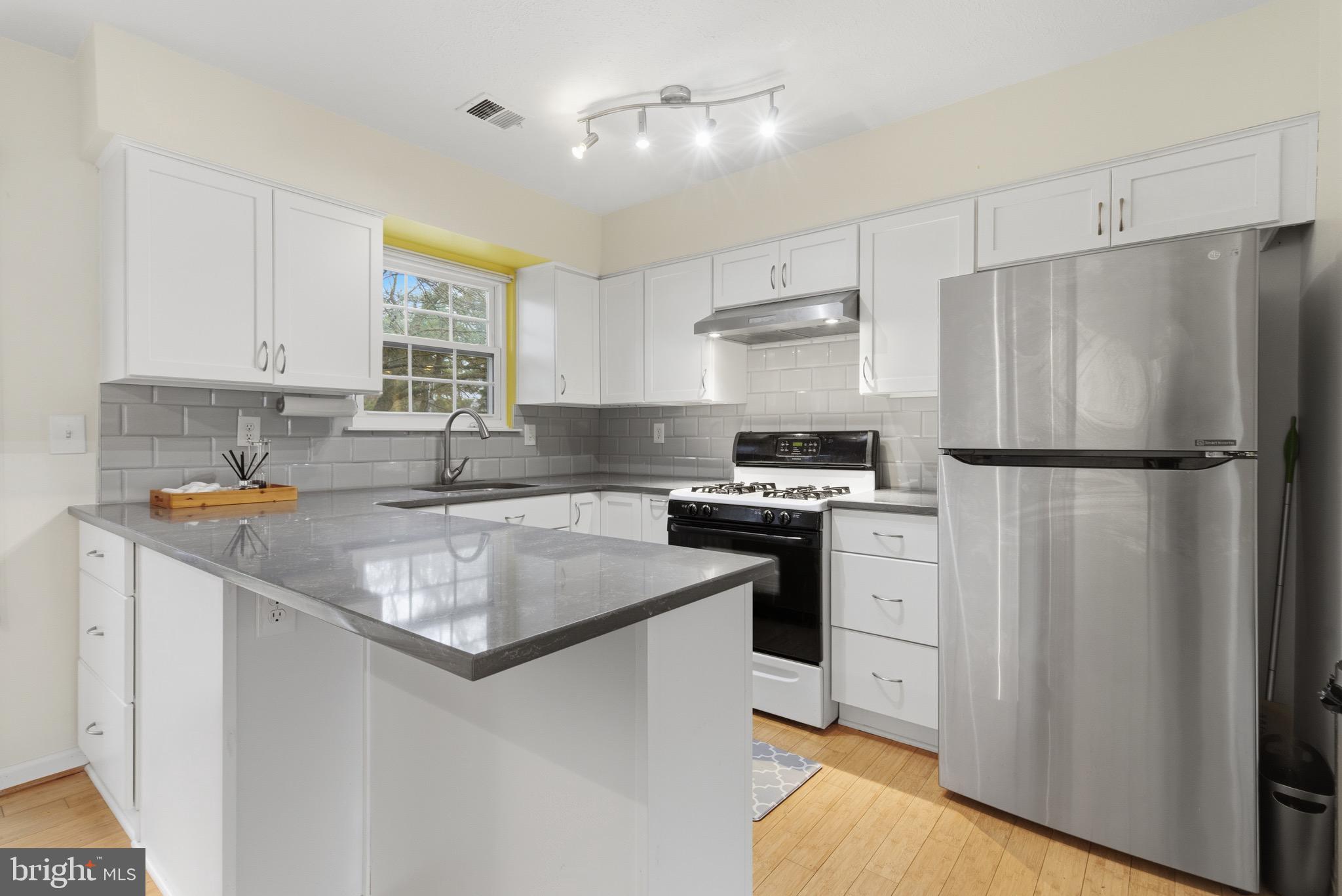 517 Pickwick Village Way Silver Spring, MD 20901 - Photo 12 of 39 a kitchen with stainless steel appliances granite countertop a refrigerator a sink a stove a microwave and island