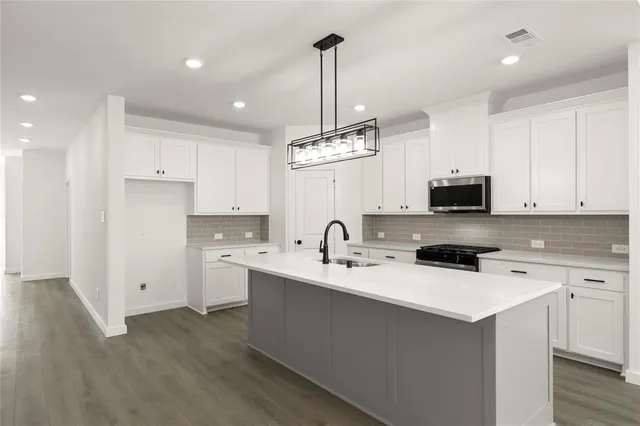 a kitchen with a sink a stove and cabinets