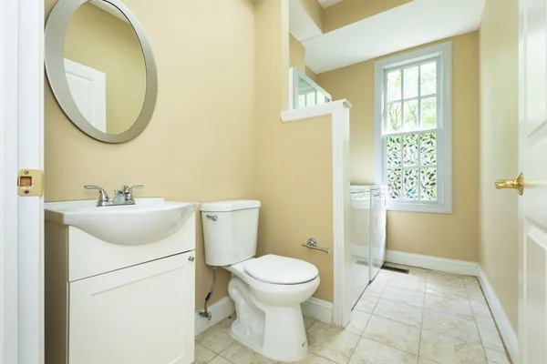 a bathroom with a toilet sink and mirror