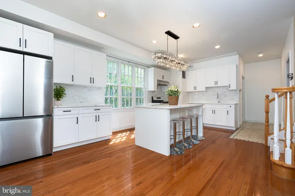 a kitchen with kitchen island white cabinets and stainless steel appliances
