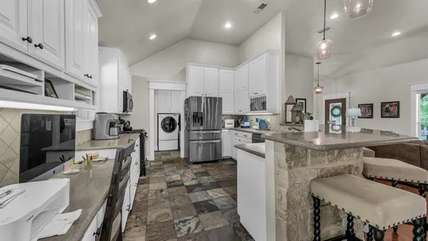 a kitchen with white cabinets and stainless steel appliances